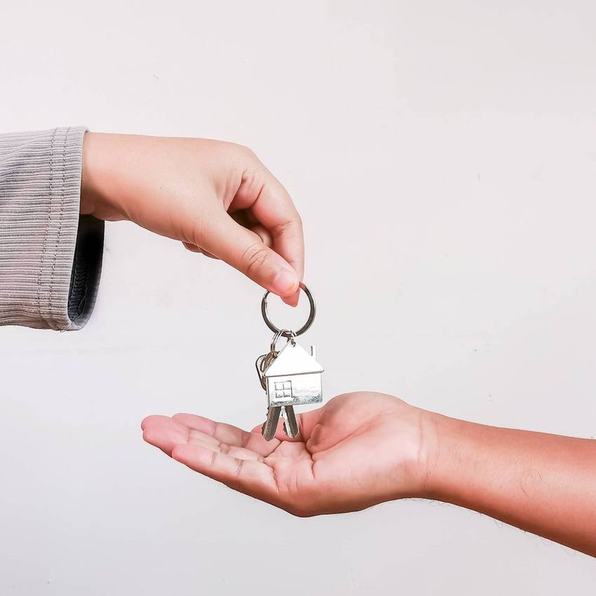 One person handing a set of house keys to another